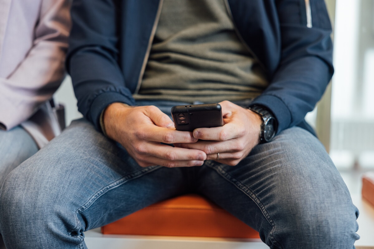 Man op telefoon in wachtkamer Jong JGZ