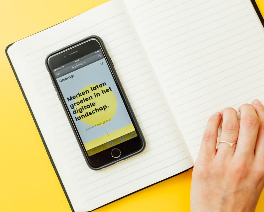 telefoon met homepagina groowup op schriftje